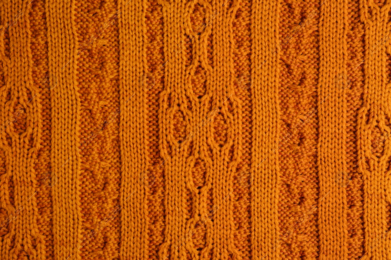 Photo of Beautiful orange knitted fabric as background, top view