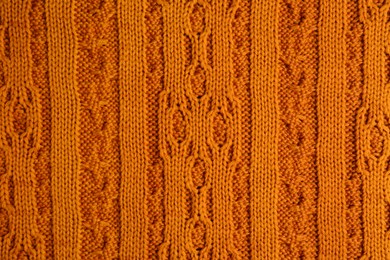 Beautiful orange knitted fabric as background, top view