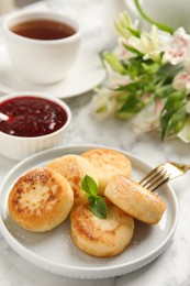 Photo of Delicious cottage cheese pancakes with mint and icing sugar on white marble table