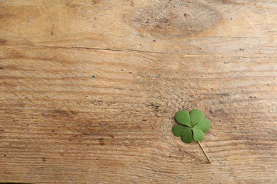 Photo of Clover leaf on wooden table, top view with space for text. St. Patrick's Day symbol