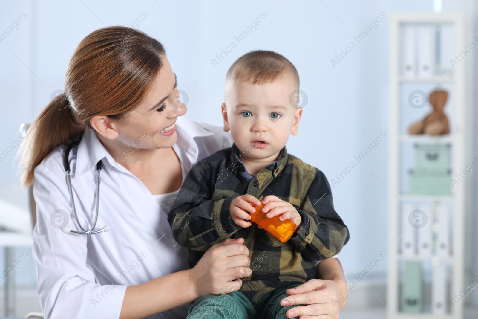 Photo of Children's doctor working with little patient in hospital. Space for text