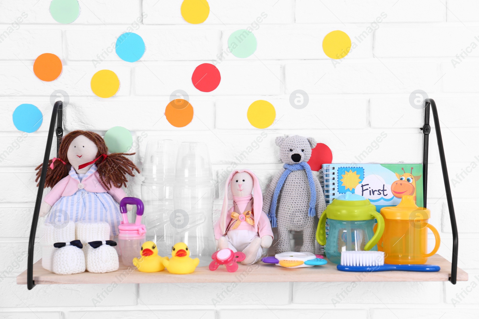 Photo of Baby accessories on shelf near white brick wall