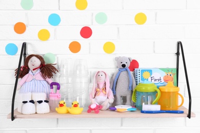 Baby accessories on shelf near white brick wall
