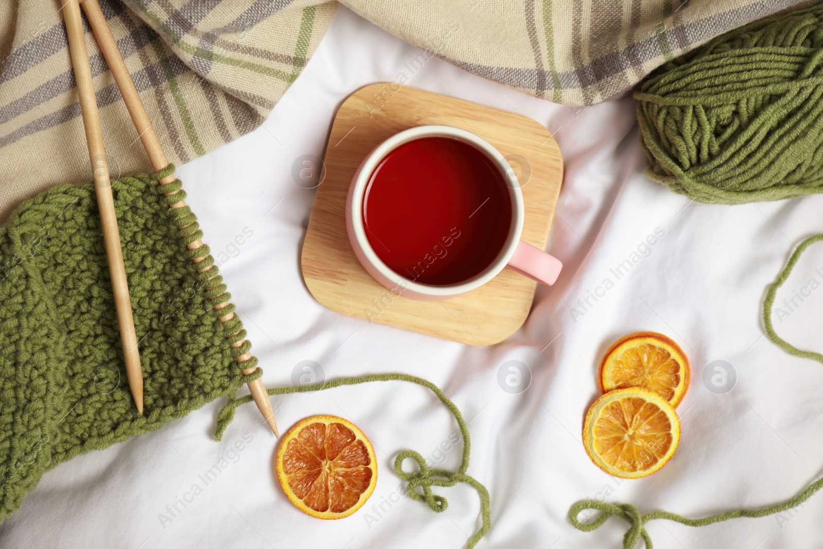 Photo of Flat lay composition with cup of hot winter drink on light fabric