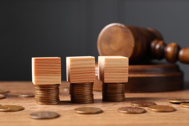 Tax law. Blank wooden cubes, coins and gavel on table, closeup