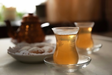 Glass cup of aromatic tea on table