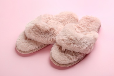 Pair of stylish soft slippers on pink background