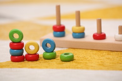 Photo of Stacking and counting game on floor indoors, closeup with space for text. Educational toy for motor skills development