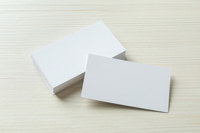 Photo of Blank business cards on white wooden table. Mockup for design