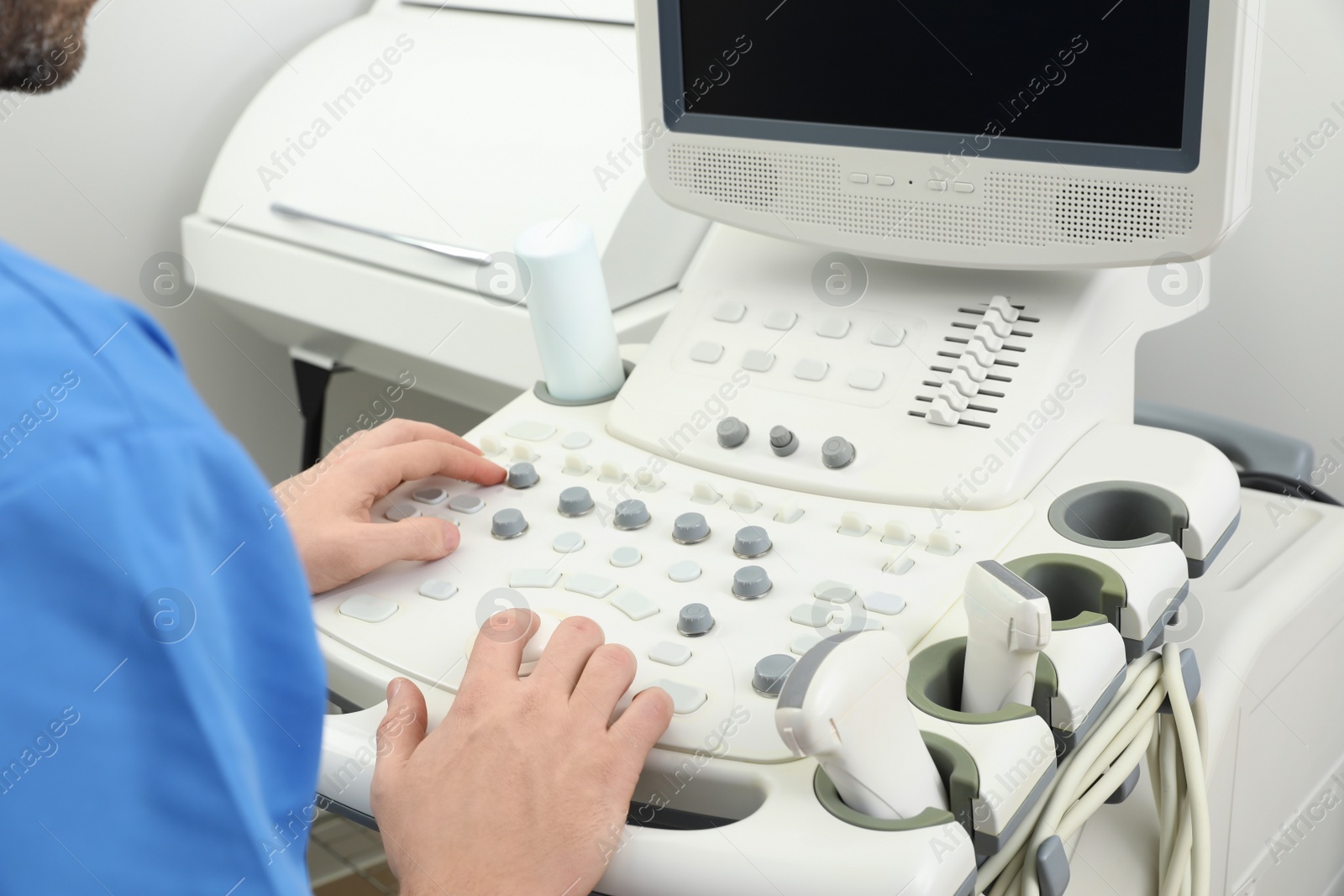 Photo of Sonographer operating modern ultrasound machine in clinic, closeup