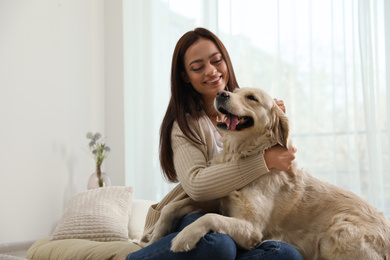 Photo of Young woman and her Golden Retriever at home. Adorable pet