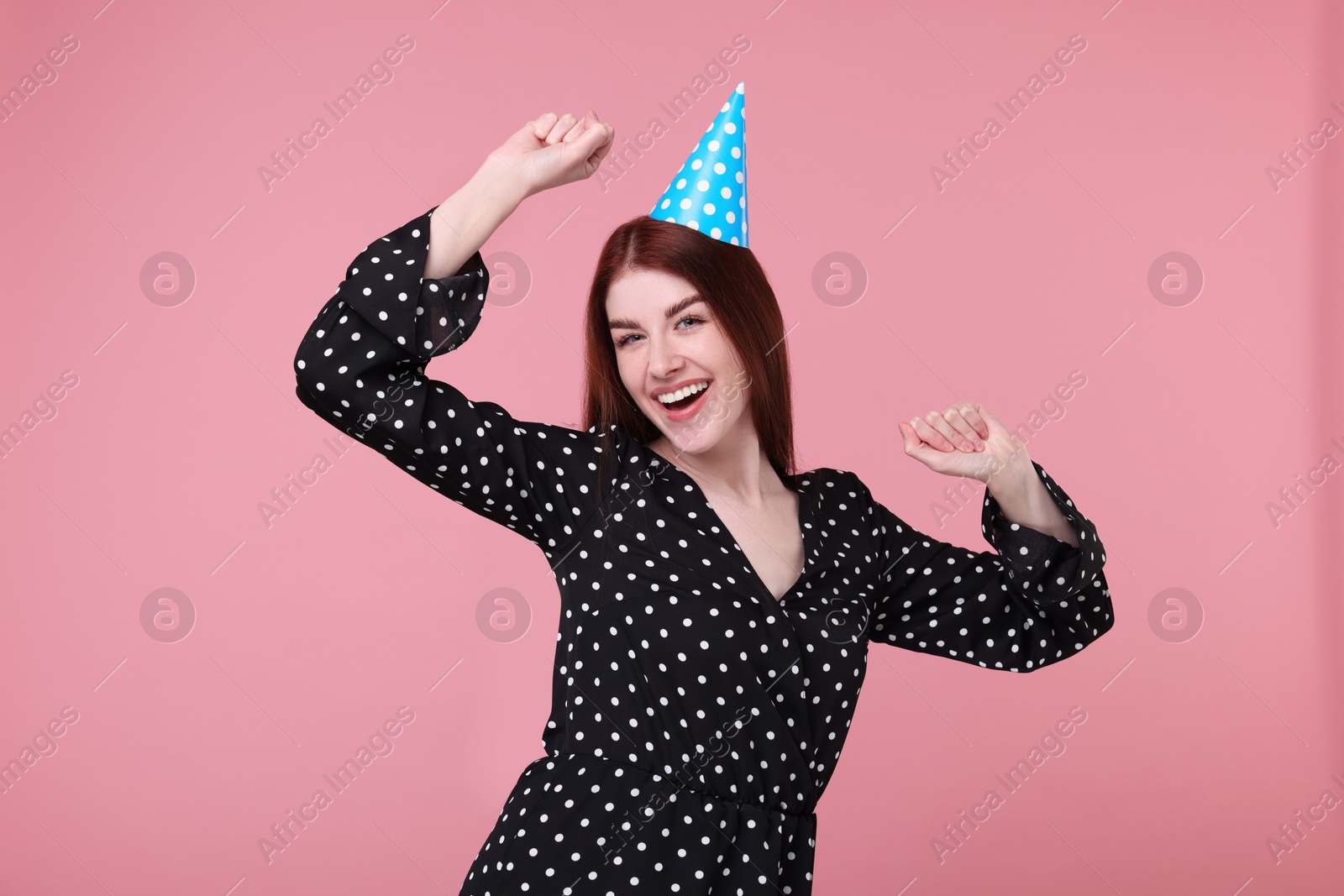 Photo of Happy woman in party hat on pink background