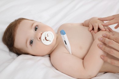 Mother measuring her baby's temperature, closeup. Health care