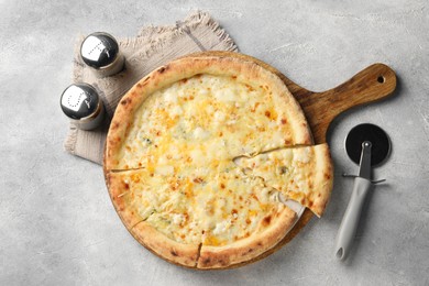 Photo of Delicious cheese pizza and cutter on light grey table, flat lay