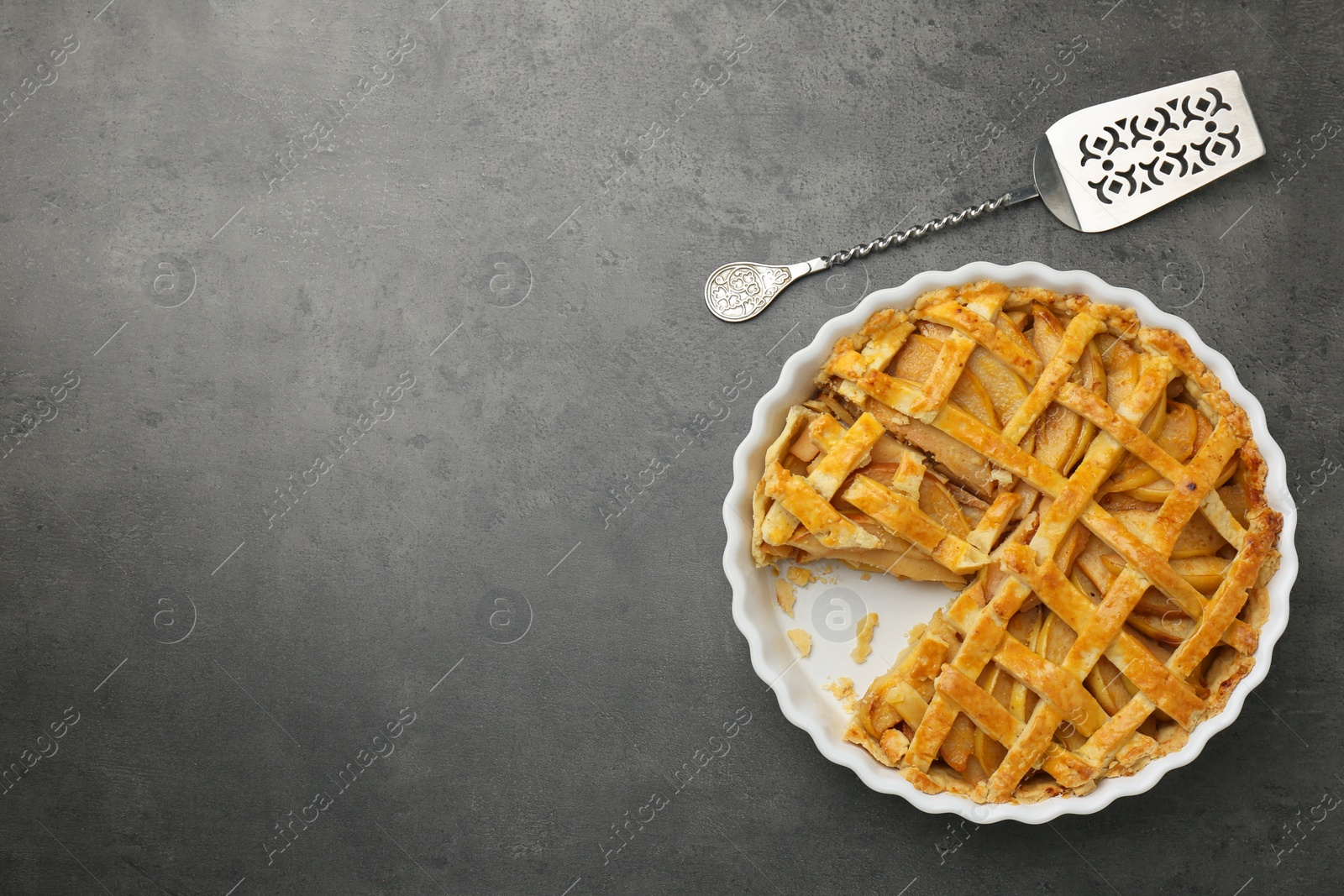 Photo of Tasty homemade quince pie with cake server on grey table, flat lay. Space for text