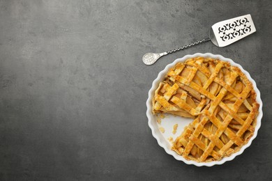 Tasty homemade quince pie with cake server on grey table, flat lay. Space for text