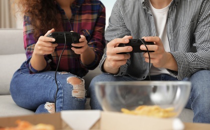 Photo of Young couple playing video games at home, closeup