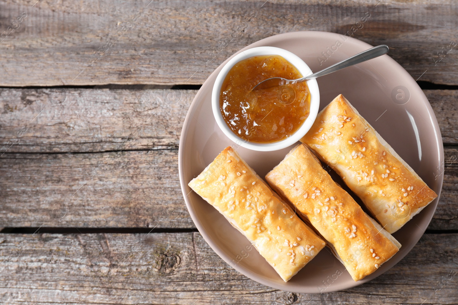 Photo of Delicious puff pastry served on wooden table, top view. Space for text