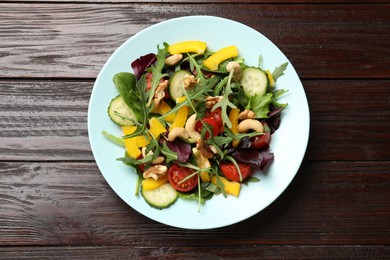 Tasty fresh vegetarian salad on dark wooden table, top view