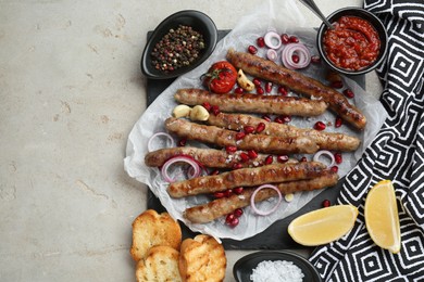 Photo of Tasty grilled sausages served on light table, flat lay. Space for text