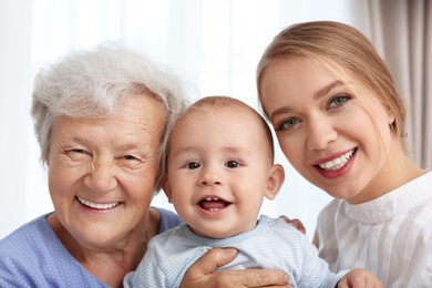 Photo of Happy young woman with her child and grandmother at home