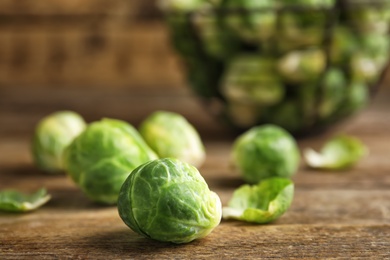 Photo of Fresh Brussels sprouts on wooden table, closeup