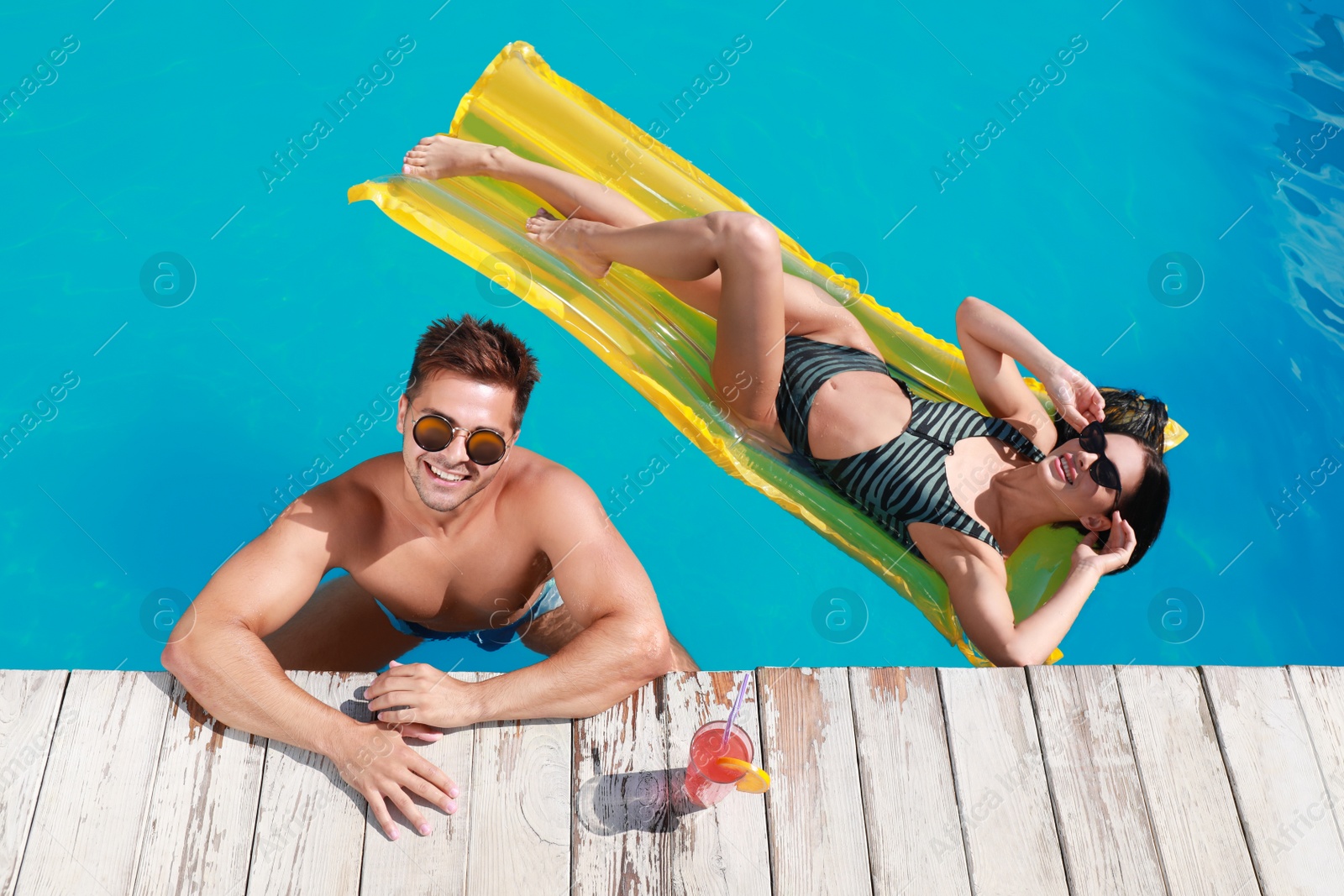 Photo of Happy young couple in outdoor swimming pool, above view