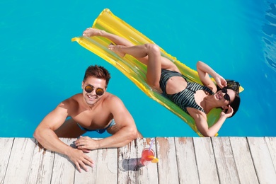 Happy young couple in outdoor swimming pool, above view