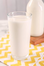 Glass of tasty milk on table, closeup