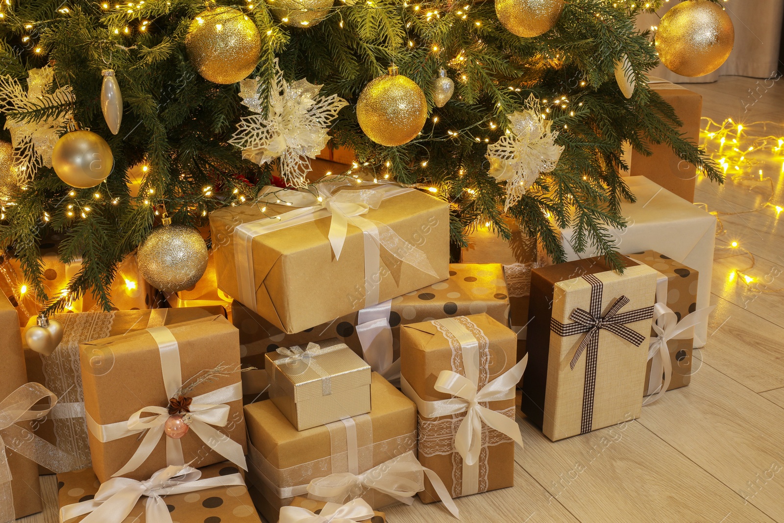 Photo of Many gift boxes under decorated Christmas tree at home