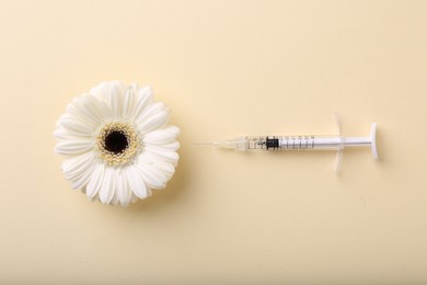 Photo of Cosmetology. Medical syringe and gerbera flower on yellow background, flat lay