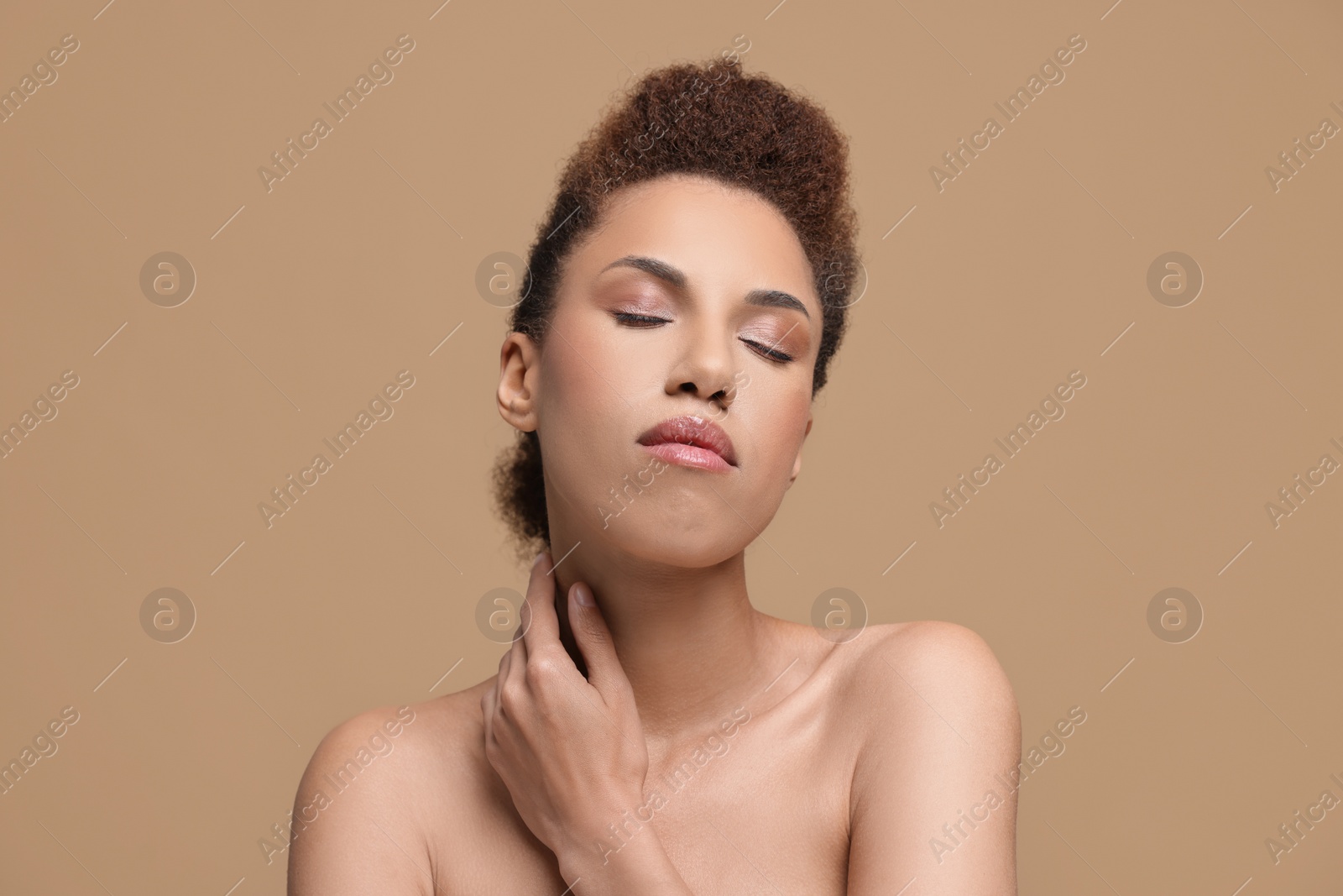 Photo of Portrait of beautiful young woman with glamorous makeup on light brown background