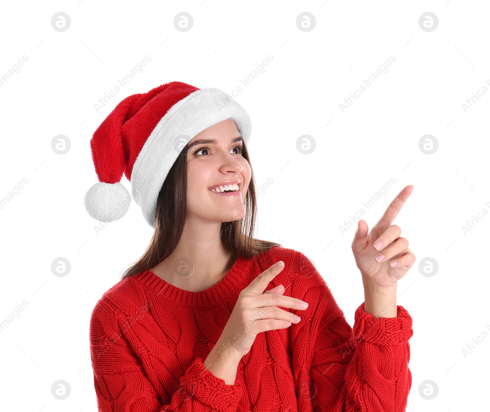 Photo of Pretty woman in Santa hat and red sweater pointing on white background
