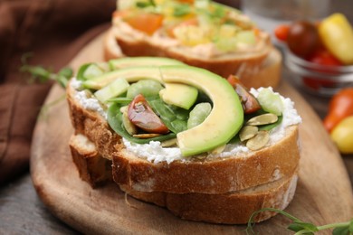 Photo of Tasty vegan sandwiches with vegetables on wooden table, closeup