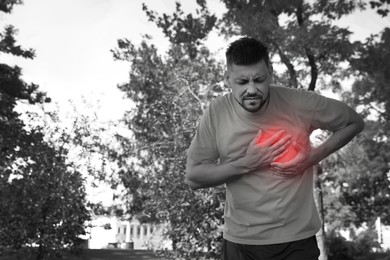 Image of Man having heart attack in park. Black and white photo