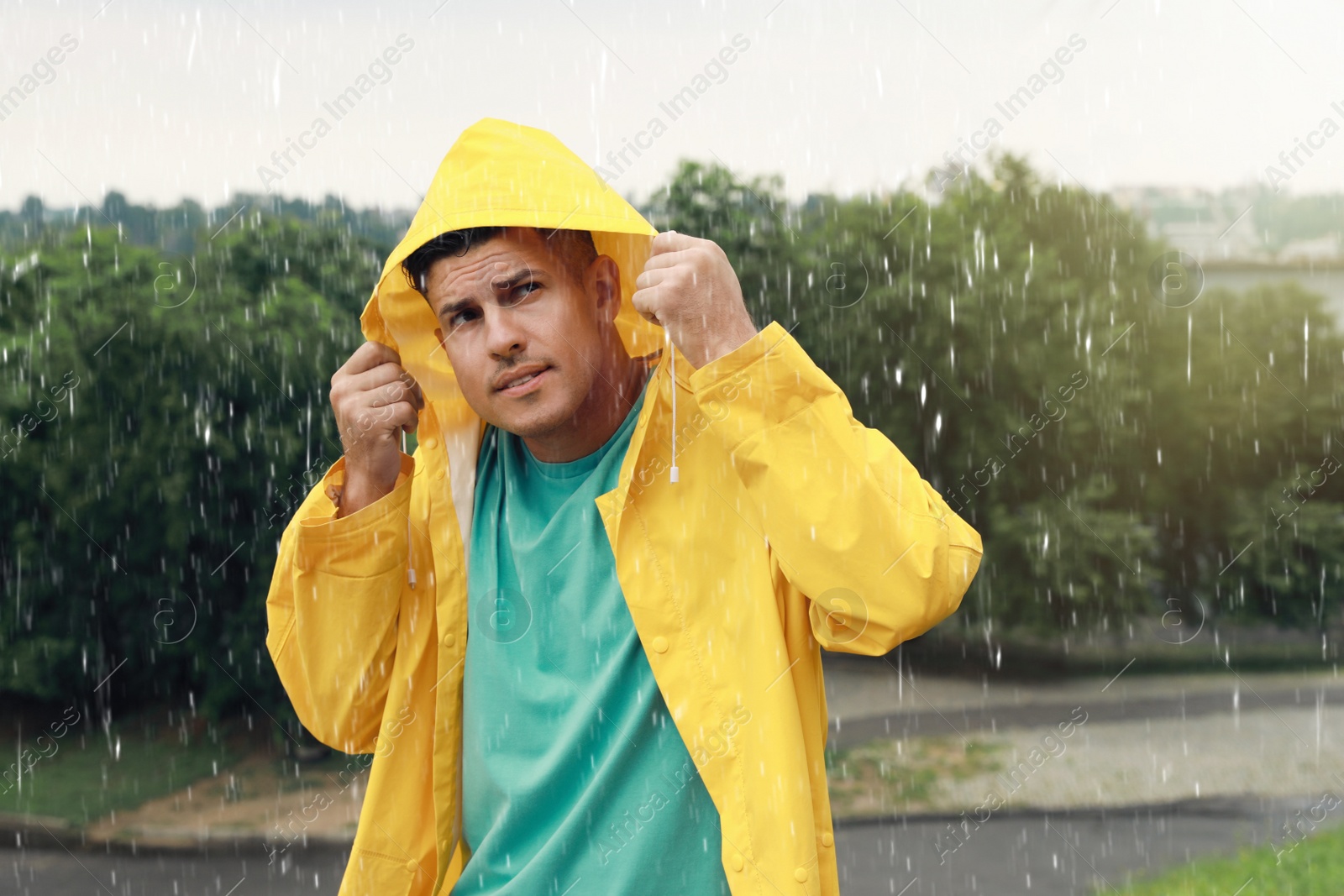 Photo of Man with raincoat walking under rain in park