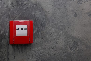 Photo of Fire alarm push button on grey wall, space for text