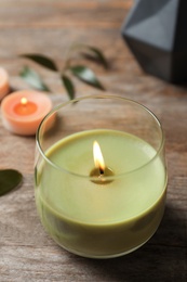 Photo of Beautiful burning wax candle on wooden table