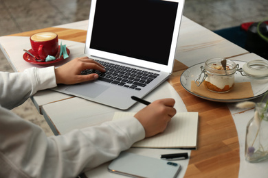 Blogger working with laptop in cafe, closeup