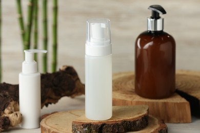 Photo of Bottles of face cleansing products on wooden stand