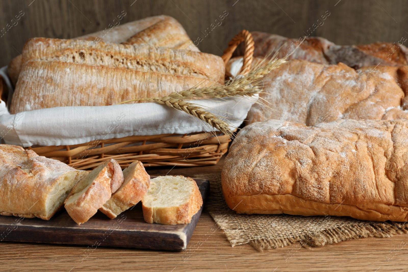 Photo of Fresh crispy ciabattas and baguette on wooden table