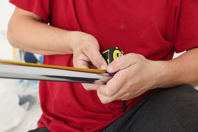 Photo of Worker measuring metal pipes for installation, closeup