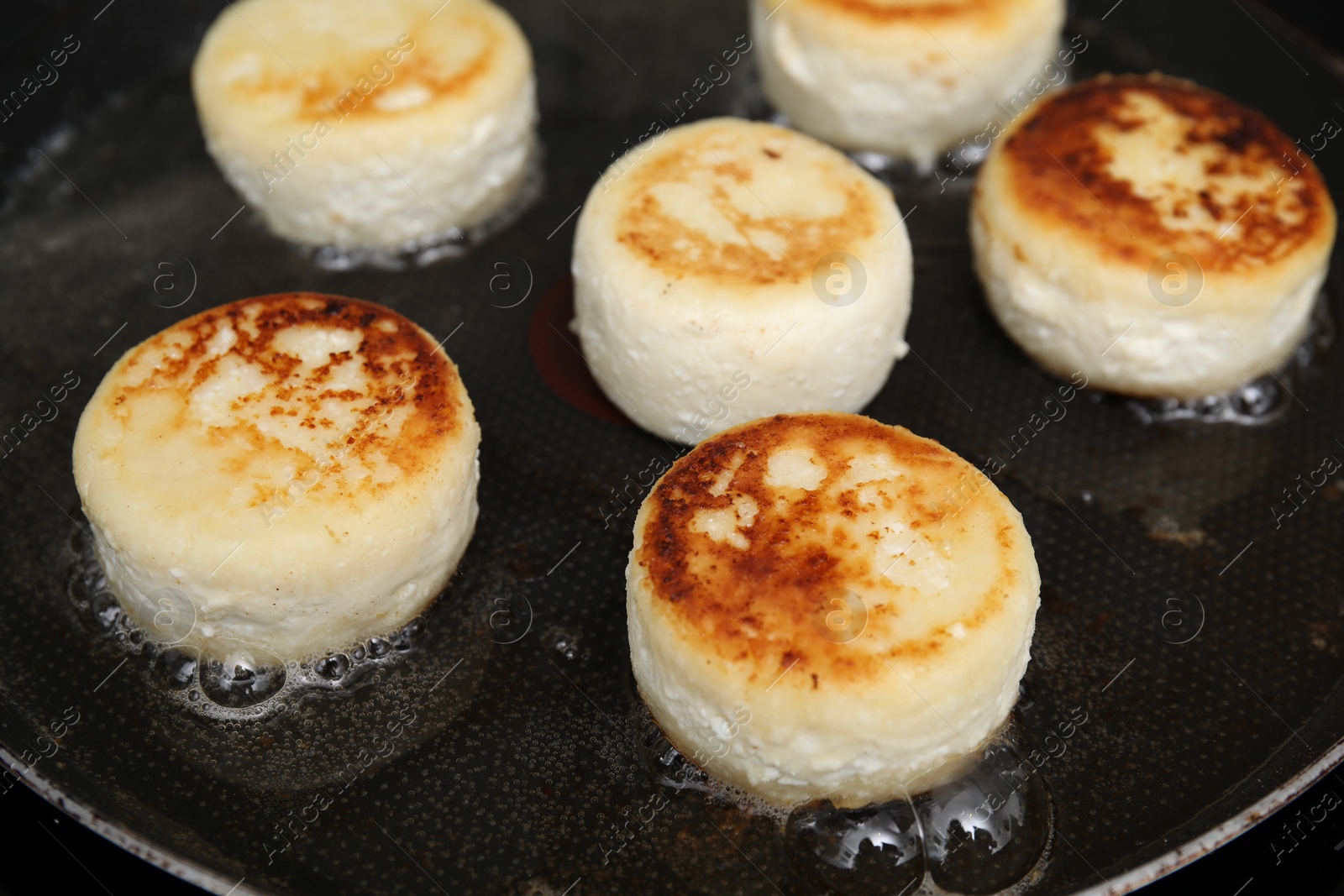 Photo of Delicious cottage cheese pancakes in frying pan, closeup