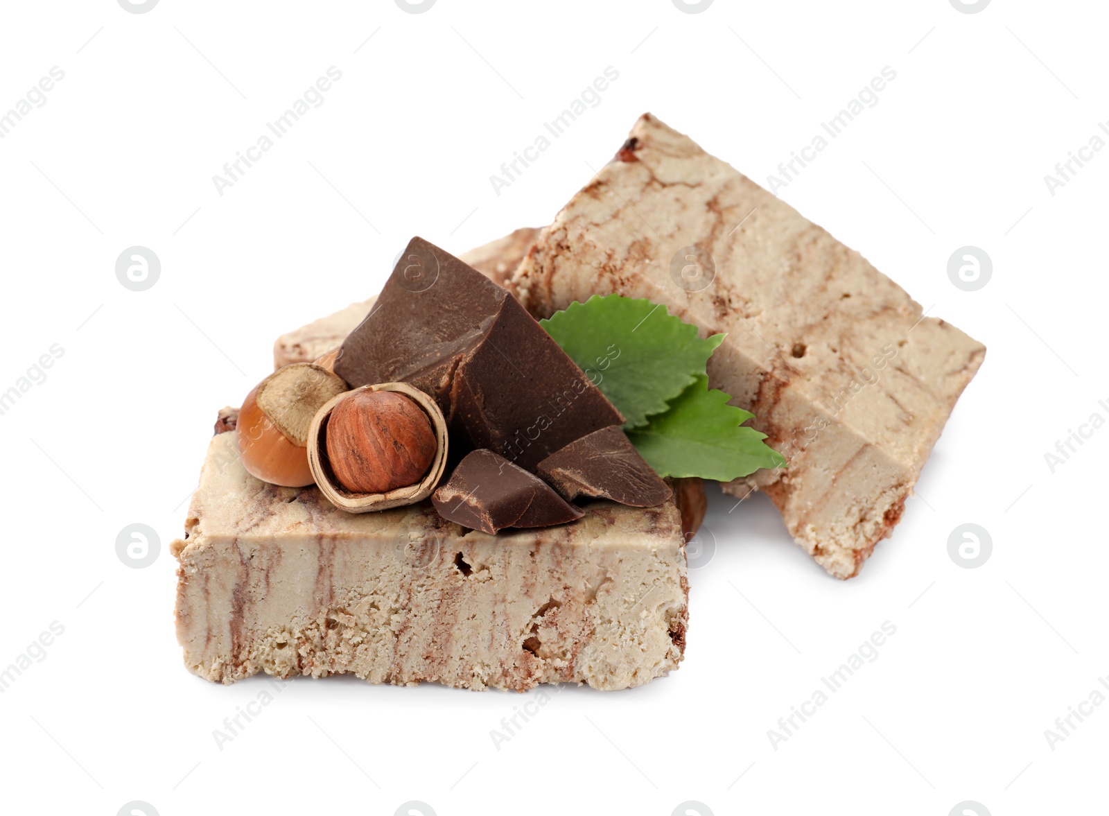 Image of Tasty halva, pieces of chocolate, hazelnuts and green leaves isolated on white