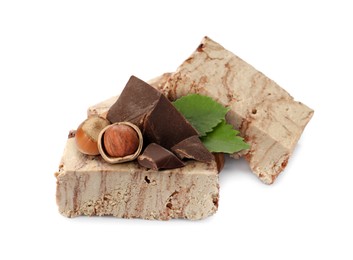 Image of Tasty halva, pieces of chocolate, hazelnuts and green leaves isolated on white