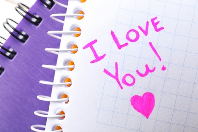 Notebook page with written words I LOVE YOU and heart, top view