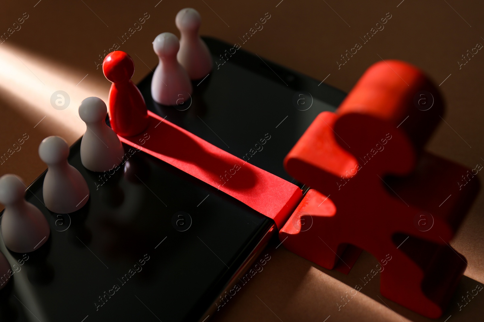 Photo of Recruitment process, job competition concept. Red pawn in beam of light among white ones as best applicant chosen by human figure on light brown background