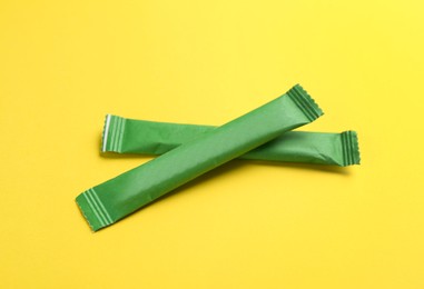 Photo of Green sticks of sugar on yellow background