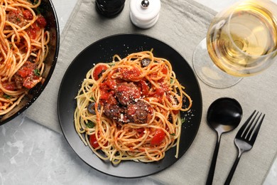 Photo of Delicious pasta with meatballs and tomato sauce served on light grey table, flat lay