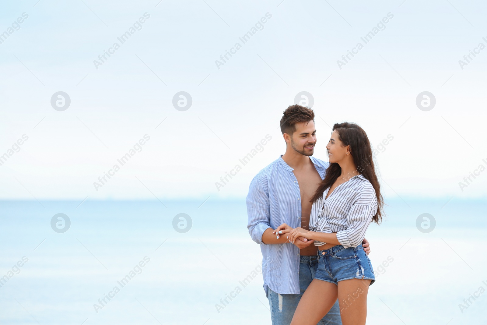 Photo of Happy young couple spending time together on beach